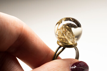 Hand holding an epoxy resin ring. Natural dried moss and small piece of lava preserved inside...