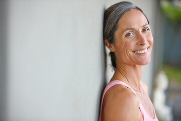 Happiness is an inside job. Portrait of an attractive mature woman in gymwear leaning against a...