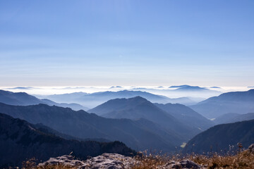 Obraz na płótnie Canvas A panoramic view on the mountain peaks of the Hochschwab Region in Upper Styria, Austria. Cloudless weather on a sunny summer day in the Alps. Blue misty valley and soft hills. Concept freedom
