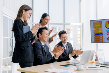Cheerful young Asian businessman Excited and glad applauded. About successful startup projects Happy Asian colleagues celebrating business success in office meeting.