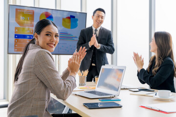 Cheerful young Asian businessman Excited and glad applauded. About successful startup projects Happy Asian colleagues celebrating business success in office meeting.