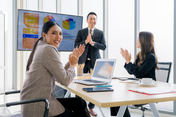 Cheerful young Asian businessman Excited and glad applauded. About successful startup projects Happy Asian colleagues celebrating business success in office meeting.