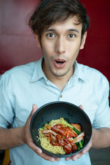 Excited man eating Chinese noodle street food