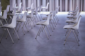 Many white Chairs in a Row. evocative series of chairs. rows of chairs, empty seats - chair row