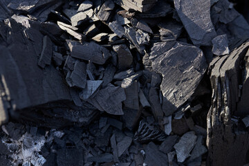 Black coal texture background. close-up. charcoal is a lightweight black carbon residue produced by...