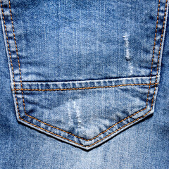 Blue jeans back pocket with holes and scuffs, seam and orange thread stitches for fashion...