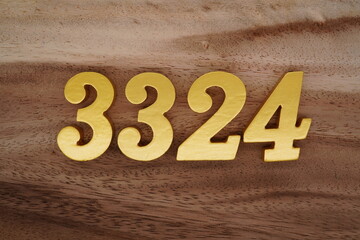 Golden Arabic numerals on a real brown and white wooden floor number 3324