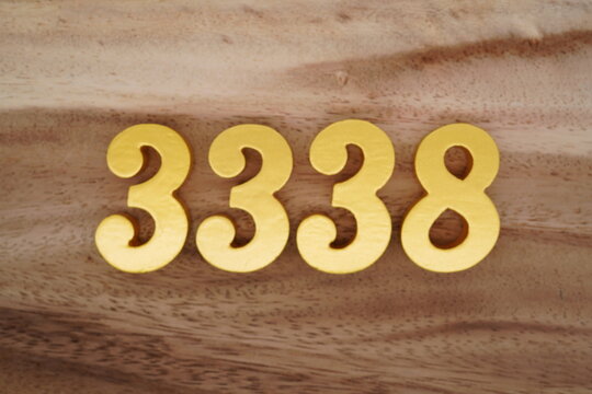 Golden Arabic numerals on a real brown and white wooden floor number 3338