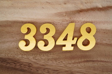 Golden Arabic numerals on a real brown and white wooden floor number 3348