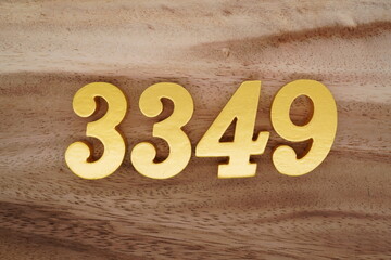 Golden Arabic numerals on a real brown and white wooden floor number 3349