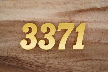 Golden Arabic numerals on a real brown and white wooden floor number 3371