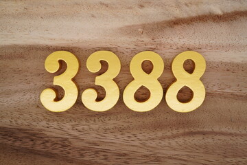 Golden Arabic numerals on a real brown and white wooden floor number 3388