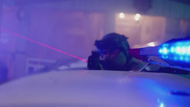 4k Special Force or police man holding weapon near car flasher or roof . Close up view of Police surrounding . Military police or lasertag concept . Shot on ARRI Alexa cinematic camera in slow motion