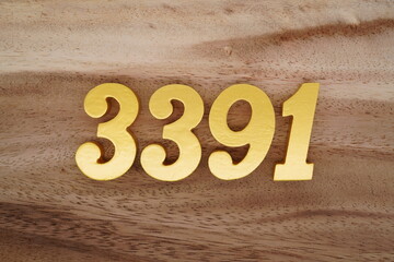 Golden Arabic numerals on a real brown and white wooden floor number 3391