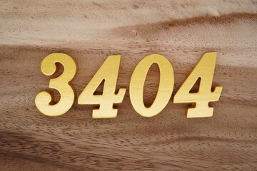 Golden Arabic numerals on a real brown and white wooden floor number 3404