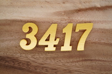 Golden Arabic numerals on a real brown and white wooden floor number 3417