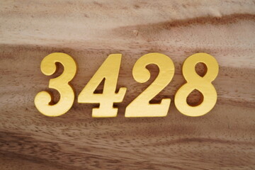 Golden Arabic numerals on a real brown and white wooden floor number 3428