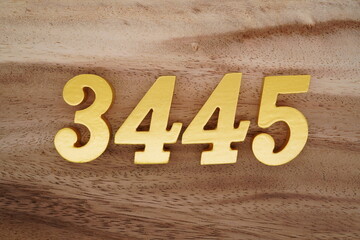Golden Arabic numerals on a real brown and white wooden floor number 3445