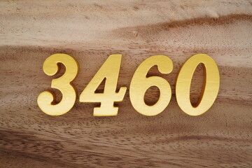Golden Arabic numerals on a real brown and white wooden floor number 3460