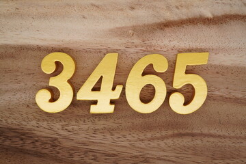 Golden Arabic numerals on a real brown and white wooden floor number 3465