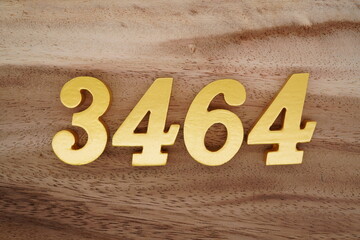 Golden Arabic numerals on a real brown and white wooden floor number 3464