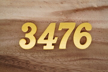 Golden Arabic numerals on a real brown and white wooden floor number 3476