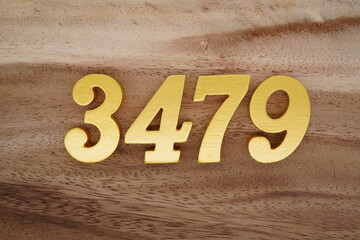 Golden Arabic numerals on a real brown and white wooden floor number 3479