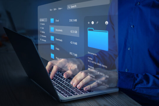 File manager used to browse folders on computer. Exploring directories on hard drive. Document management system (DMS). Business data and process. Person working on laptop.