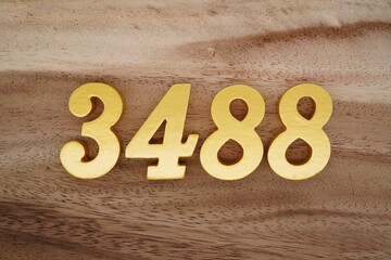 Golden Arabic numerals on a real brown and white wooden floor number 3488