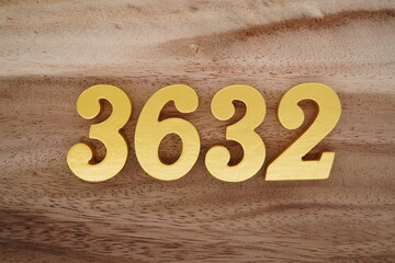 Golden Arabic numerals on a real brown and white wooden floor number 3632