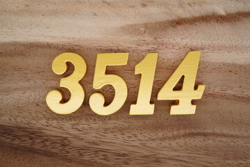 Golden Arabic numerals on a real brown and white wooden floor number 3514