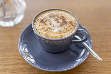 Morning cup of coffee on the background of the window in the backlight of natural sunlight.