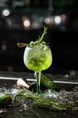 Alcoholic green drink in a glass, cocktail. Photography of drinks on a dark background