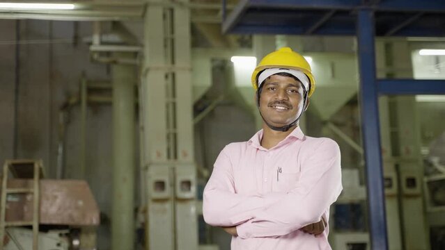 confident supervisor standing with crossed arms by looking at camera at factory - concept of professional occupation, successful worker and leadership.