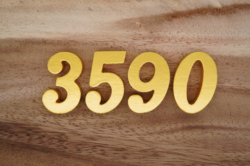 Golden Arabic numerals on a real brown and white wooden floor number 3590