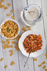 Cooking Macaroni with tomatoes. Photo of food on a light background.