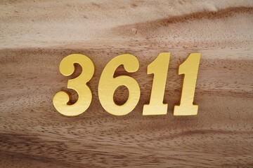 Golden Arabic numerals on a real brown and white wooden floor number 3611