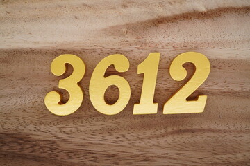 Golden Arabic numerals on a real brown and white wooden floor number 3612