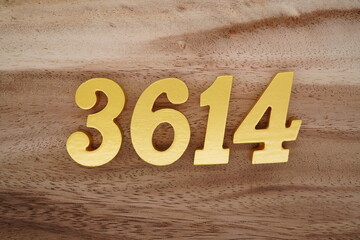 Golden Arabic numerals on a real brown and white wooden floor number 3614