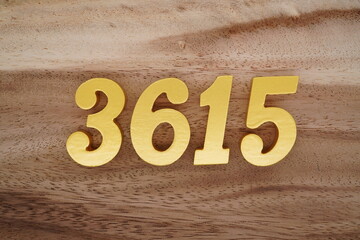 Golden Arabic numerals on a real brown and white wooden floor number 3615