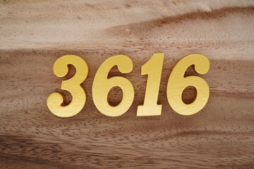 Golden Arabic numerals on a real brown and white wooden floor number 3616