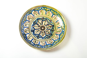 A beautiful ceramic dish with an ethnic ornament on a white background