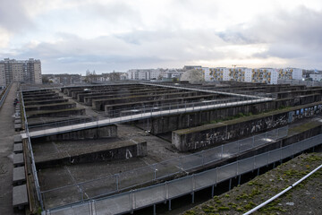 Fototapeta na wymiar Saint Nazaire, France - March 2, 2022: German submarine base in Saint Nazaire. It's a fortified U-boot pens built by Germany during the Second World War. Cloudy winter day. Selective focus.