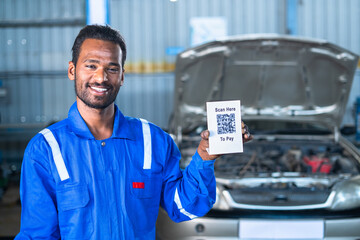 car mechanic showing scan here to pay qr code board for payment by looking camera - concept of...