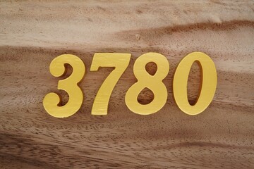 Golden Arabic numerals on a real brown and white wooden floor number 3780
