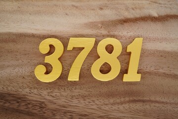Golden Arabic numerals on a real brown and white wooden floor number 3781
