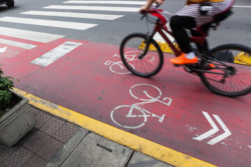 bicyclist on red bike path in modern city