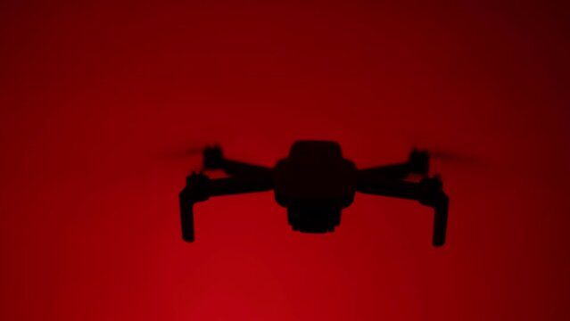 Silhouette Close up footage of a drone on a red background.