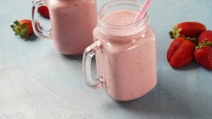 Strawberry milkshake in mason jars with fresh strawberries