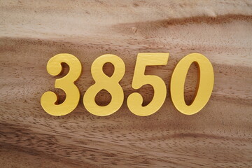 Golden Arabic numerals on a real brown and white wooden floor number 3850